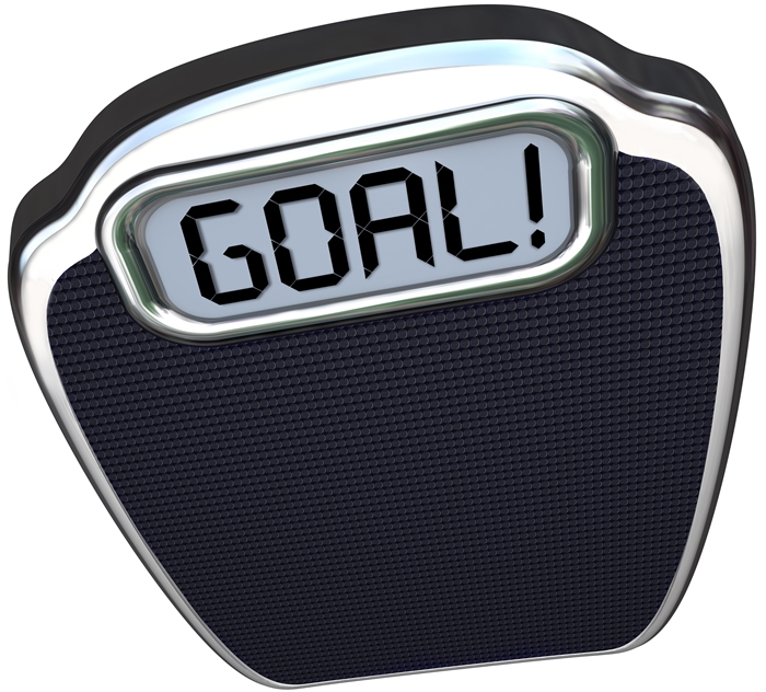 The word Goal on a scale to illustrate you have reached your target weight loss through diet and exercise and are now lighter and healthier